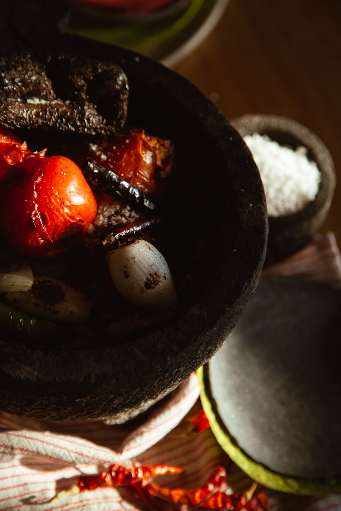 Roasted tomatoes, garlic and dried chiles in a stone molcajete in the sun
