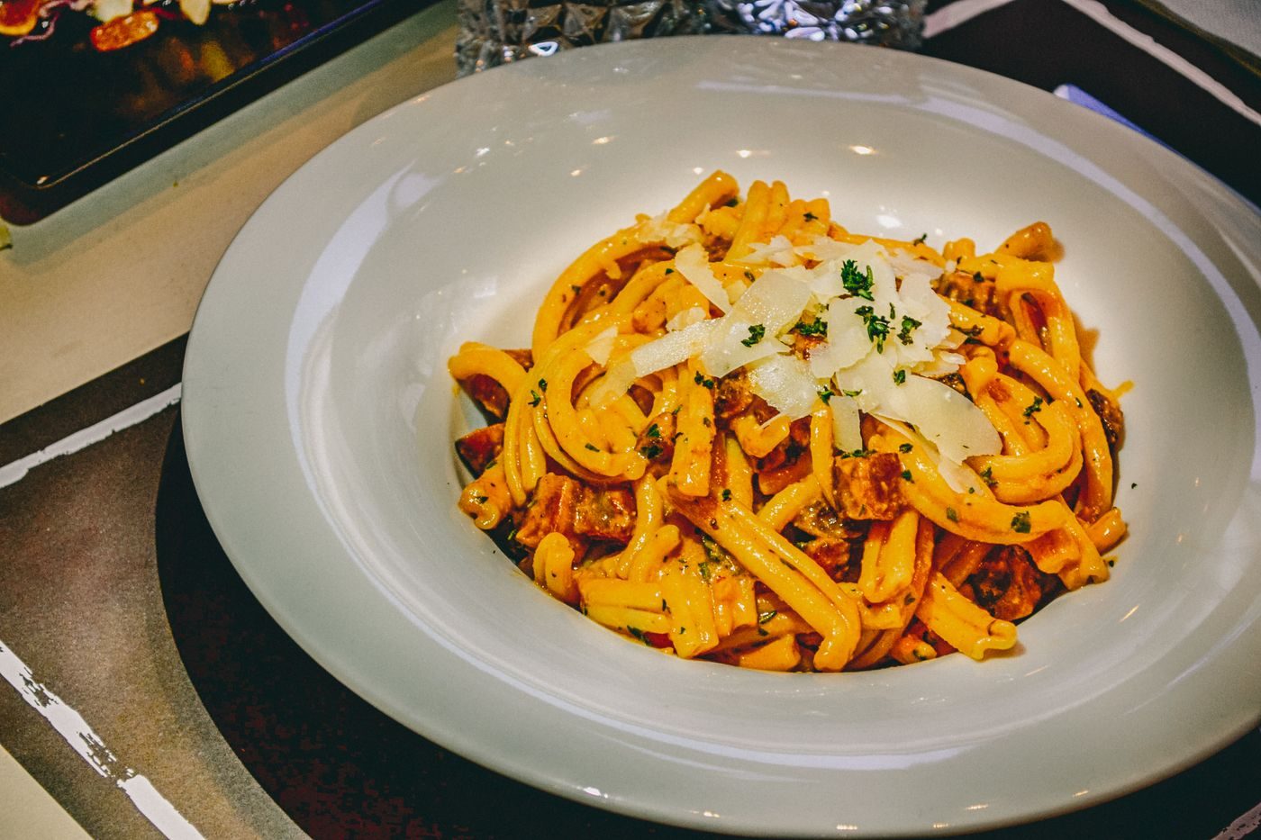 Hand-cut tagliatelle ribboned through a tomato ragù, dusted with parmesan