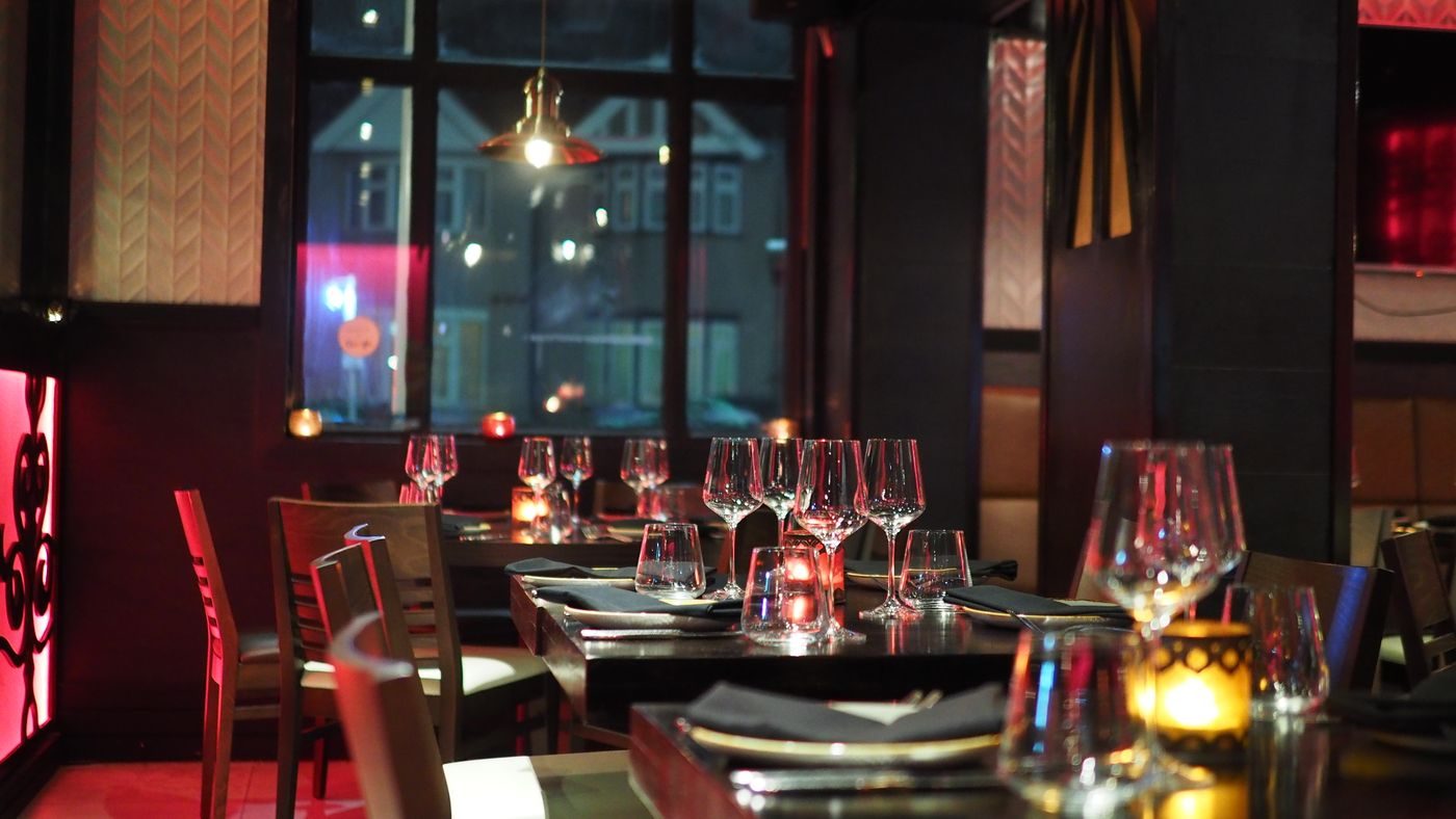 A table set for the evening with rows of wine glasses in bright light